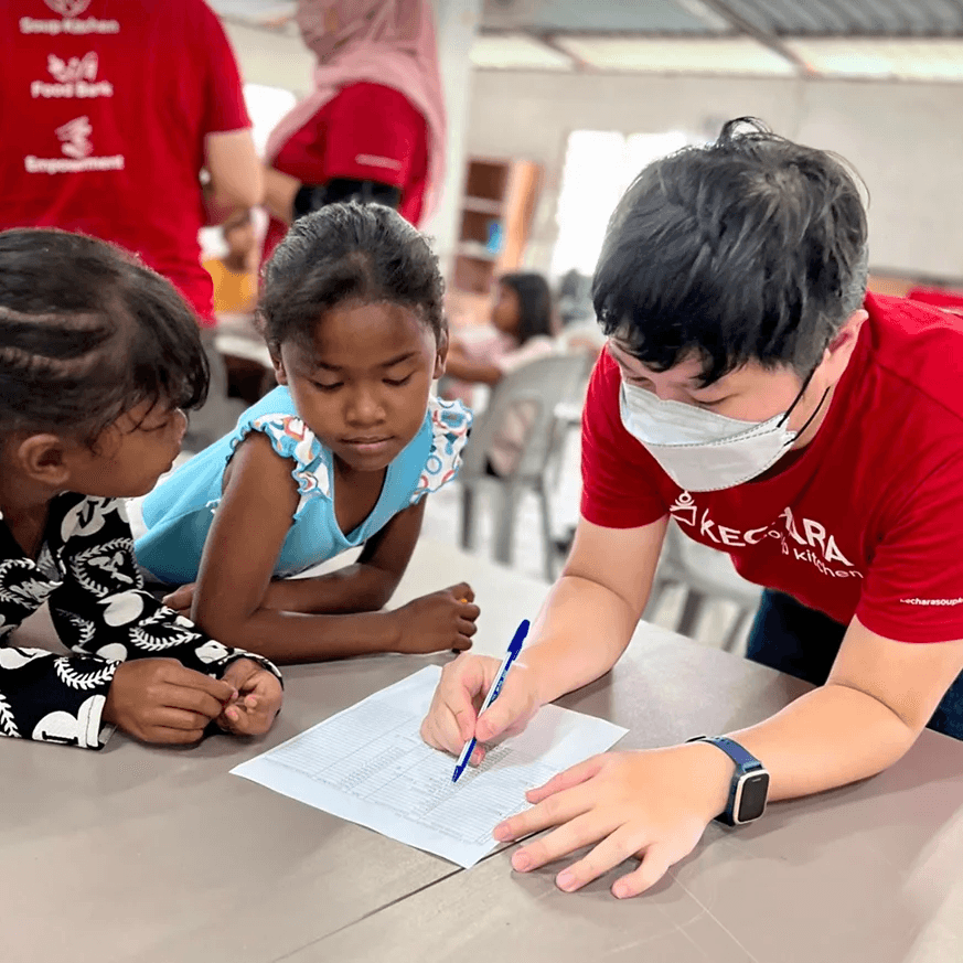A volunteers teaching Orang Asli kids how to count
